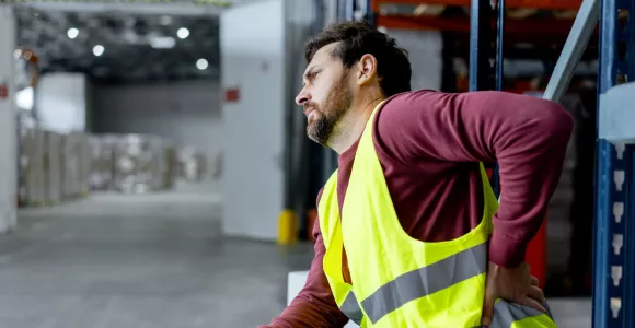 Une homme souffre du dos au travail mais ne peut s'absenter pour aller chez le médecin
