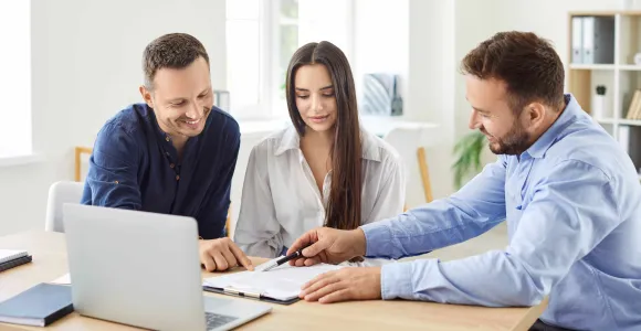 Deux hommes et une femme consultent des informations sur un ordinateur