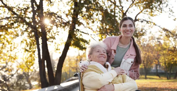 Une vieille dame et une garde à domicile, posent en souriant, montrant le lien qui s'est tissé au fil du temps passé ensemble
