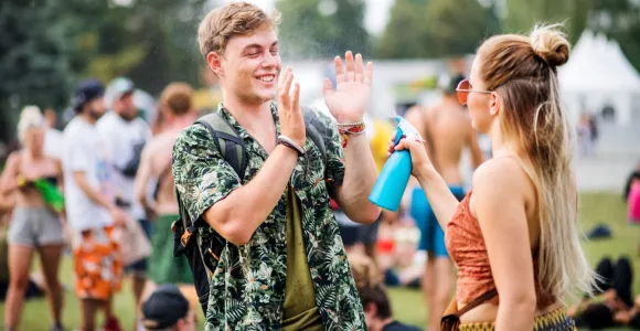 Deux personnes sont à un festival de musique et s'aspergent d'eau