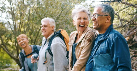 4 seniors marchent et rient en pleine nature