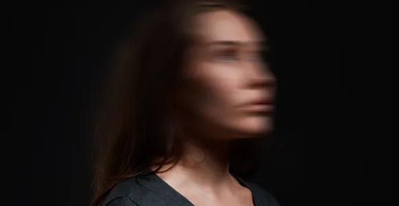 Image d'une femme debout dont le visage est flouté comme si elle vivait un séisme