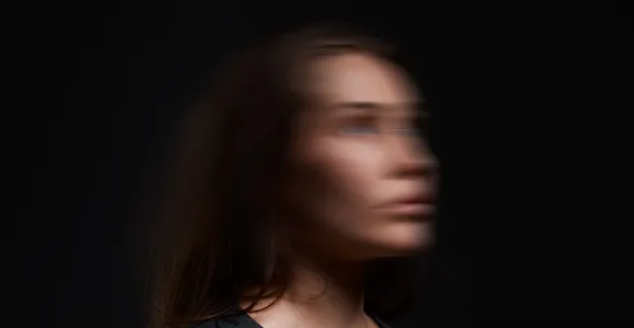 Image d'une femme debout dont le visage est flouté comme si elle vivait un séisme