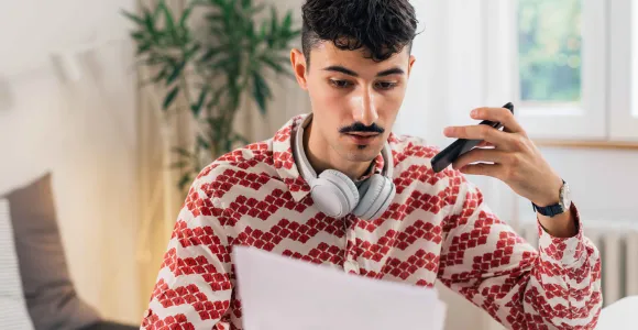 Un jeune homme lit un document papier