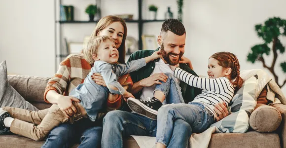 Une famille souriante assise dans un canapé