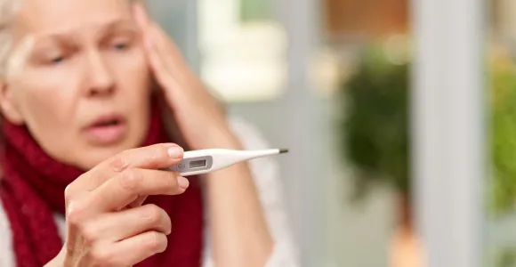 Une femme regarde un thermomètre