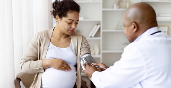 une femme enceinte se fait prendre la tension par son médecin