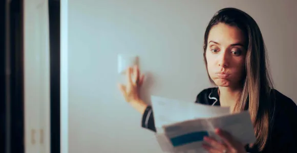 Une jeune femme soupire en parcourant sa facture
