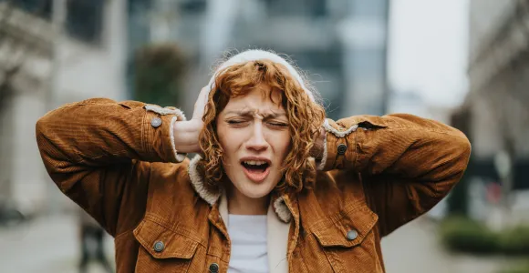 une fille se couvre les oreilles 