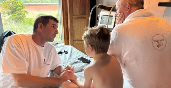 Aux thermes de Spa, Denis, kiné, aide Gabriel a retrouver de la mobilité dans sa main gauche à la suite d'une grave brûlure.
