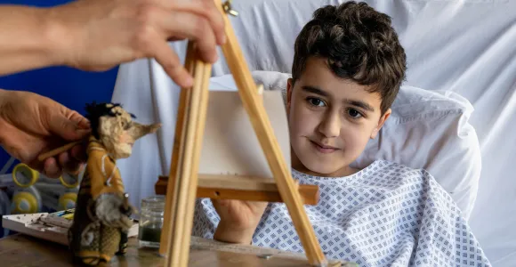 Charlotte peint le profil d’une marionnette à l’aquarelle dans le cadre d’une intervention artistique à l’hôpital.
