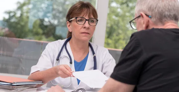 un patient en face d'une médecin qui lui donne un certificat médical