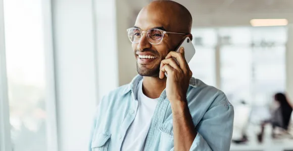 Un homme appelle via son téléphone portable en souriant