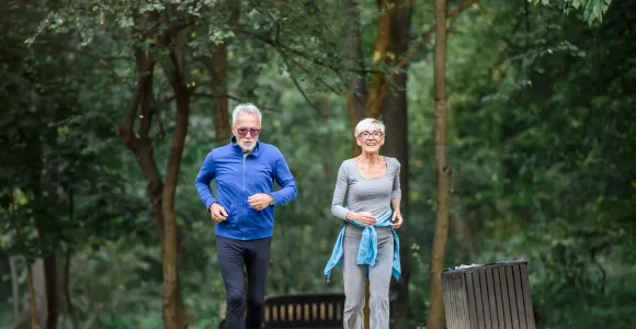 Un homme et une femme en train de courir dans un parc