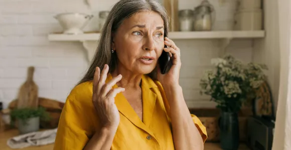 Une dame parle au téléphone de manière inquiète. 