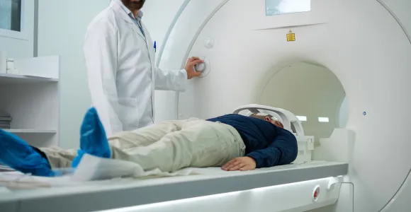 Un patient couché sur le dos entre dans un appareil IRM