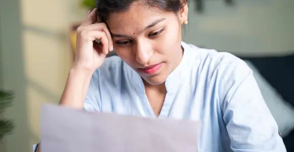 Un femme regarde un document reçu de l'Onem