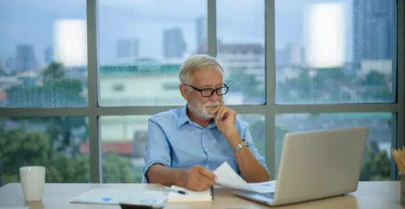 Un homme pensif au bureau derrière son écran d'ordinateur