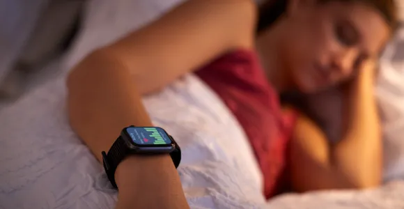 une femme dort avec sa montre connectée au poignet