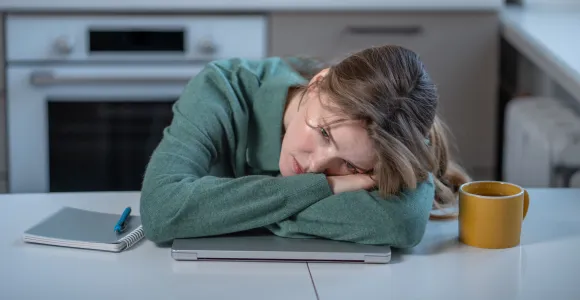 Une femme épuisée pose la tete sur sa table