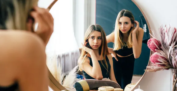 deux jeunes filles se regardent dans le miroir