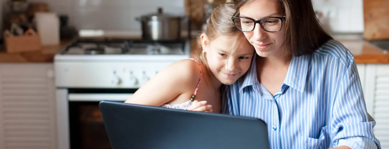 Une mère et sa fille consultent quelque chose sur un ordinateur portable