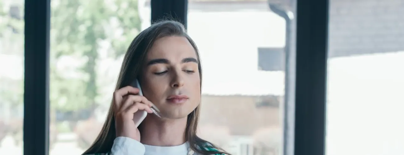 transgenre femme au téléphone avec un classeur ouvert dans l'autre main