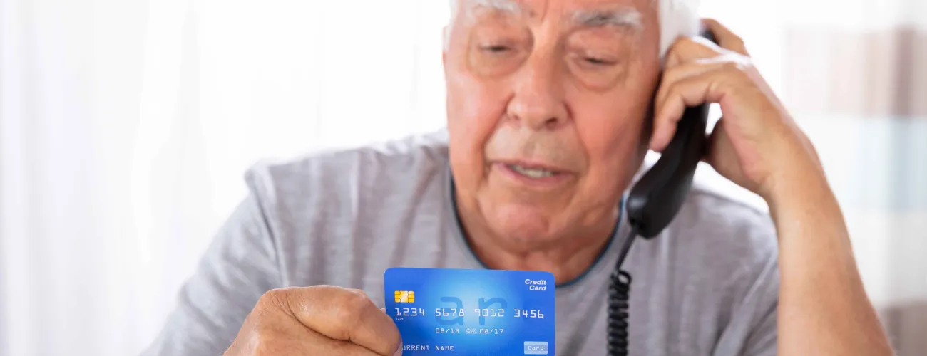 Monsieur au téléphone avec carte bancaire en main