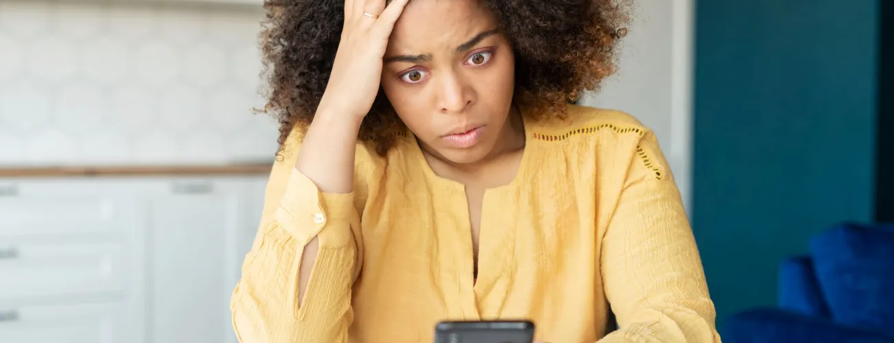 femme qui regarde son téléphone en panique 