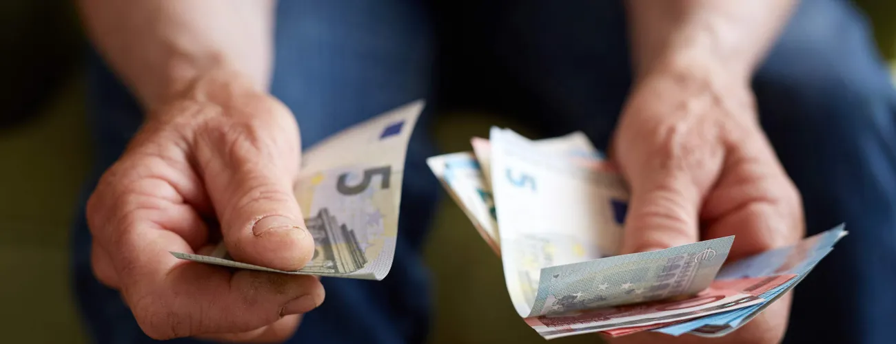 Des mains tiennent des billets d'Euros