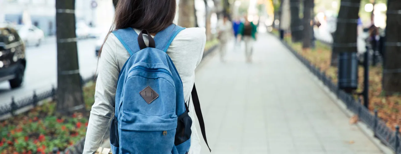 Adolescente marchant dans la rue et portant un sac à dos