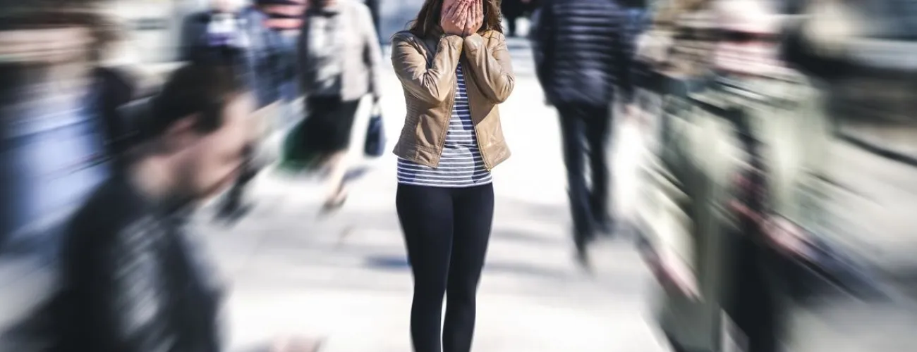 femme dans une foule les mains sur le visage