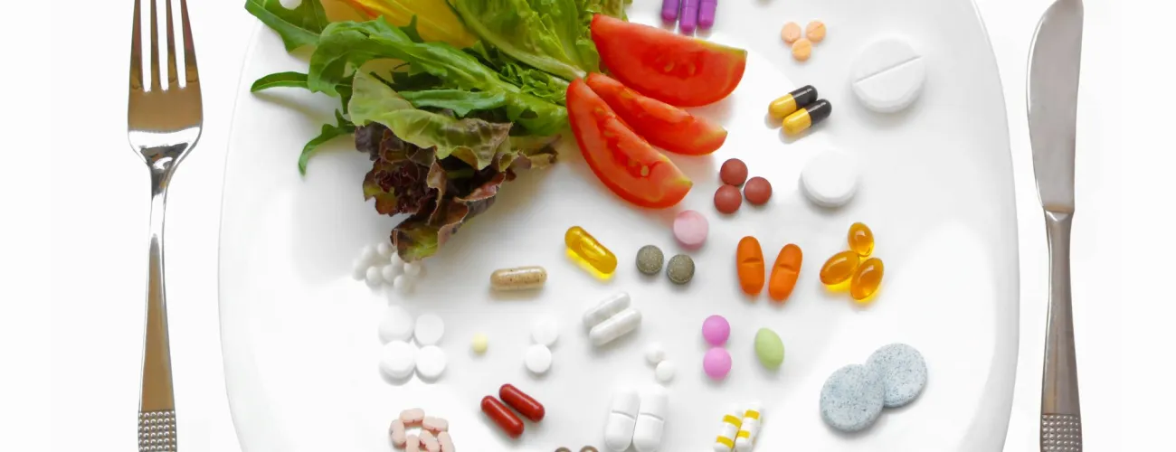 assiette avec légumes et compléments alimentaires 