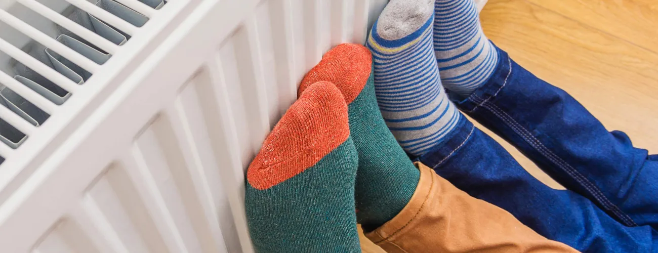 Deux personnes mettent leurs pieds en chaussettes sur le radiateur