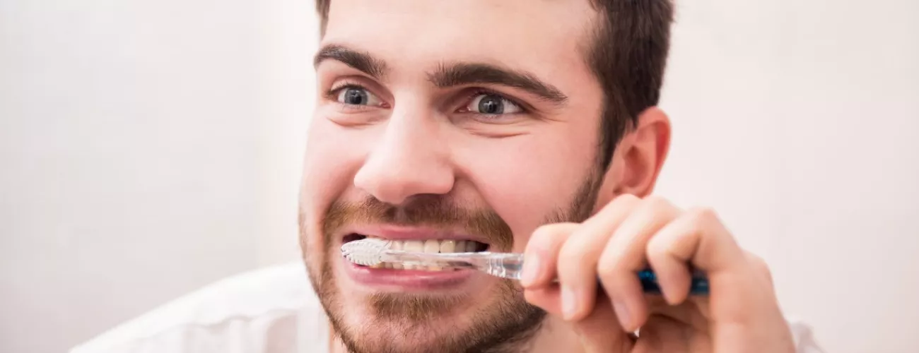 Un homme se brosse les dents