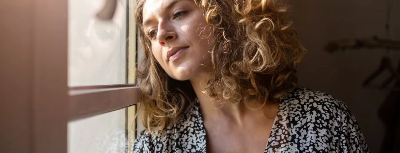 femme qui regarde par la fenêtre