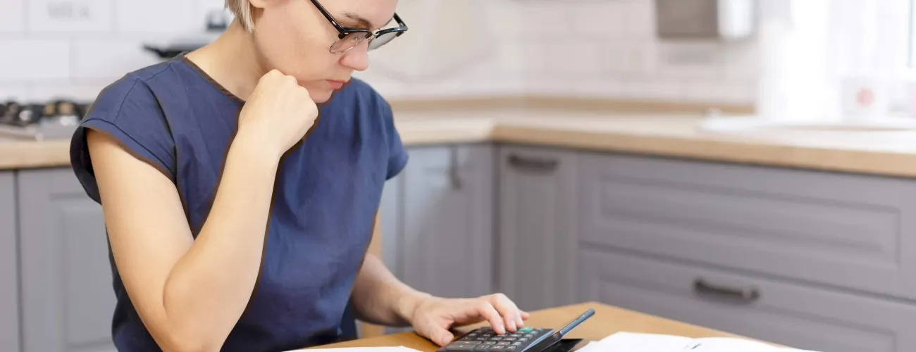 Une femme vérifie des documents à l'aide d'une calculatrice