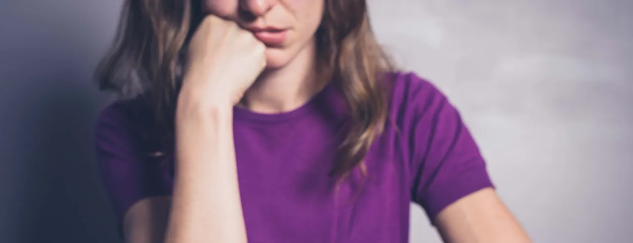 Une femme regarde son smartphone avec dépit