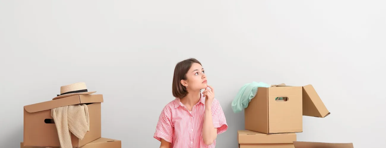 Jeune fille assise au milieu des caisses 