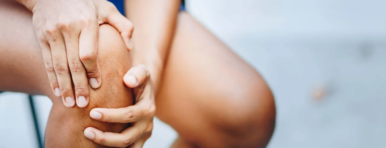 Un homme tient son genoux de douleur