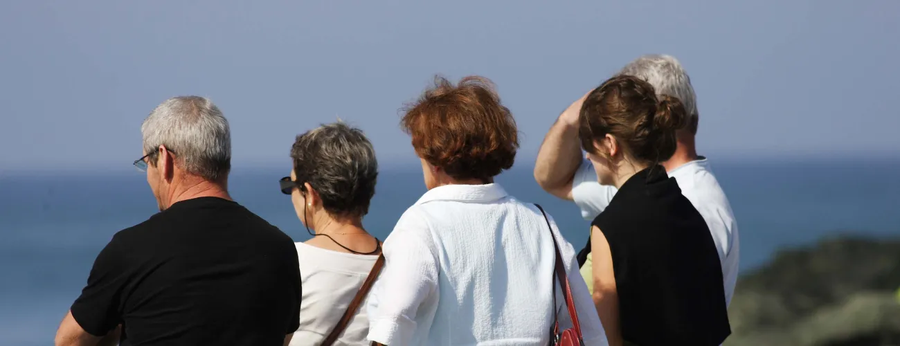 Un groupe de retraités observe une étendue d'eau