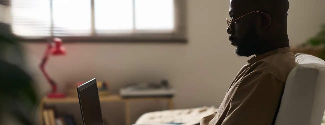 Un homme consulte son ordinateur portable dans un fauteuil