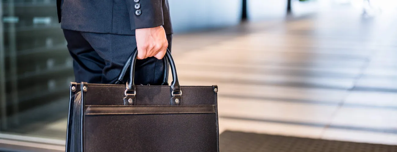 Un homme tient un porte-document en cuir