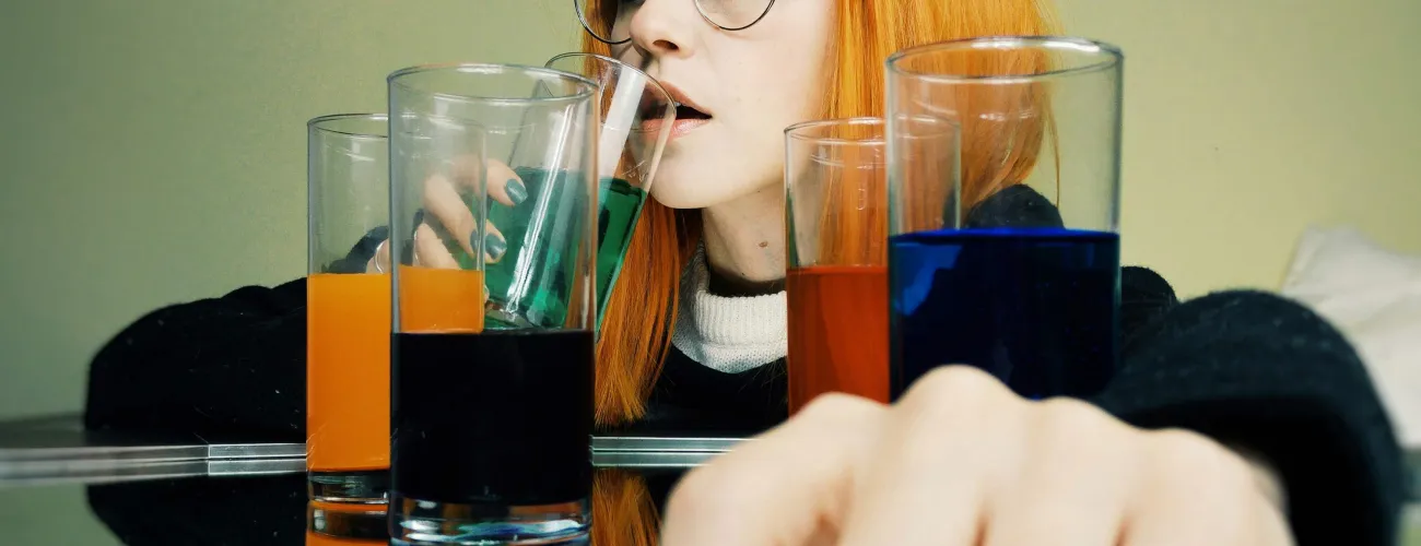 Une jeune femme boit un cocktail alcoolisé