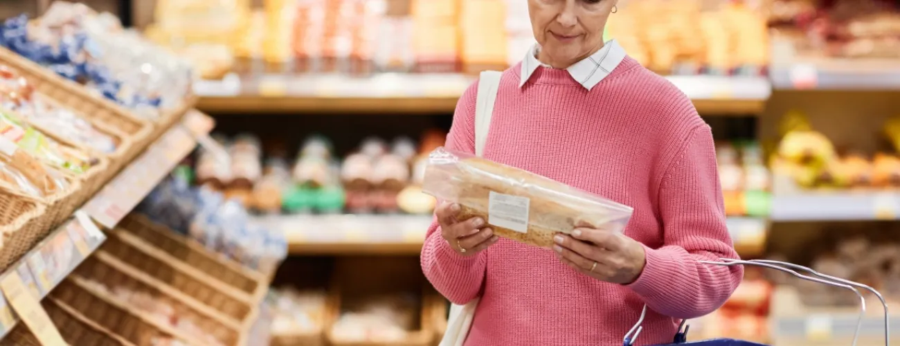 Une femme consulte l'étiquette d'un pain en magasin