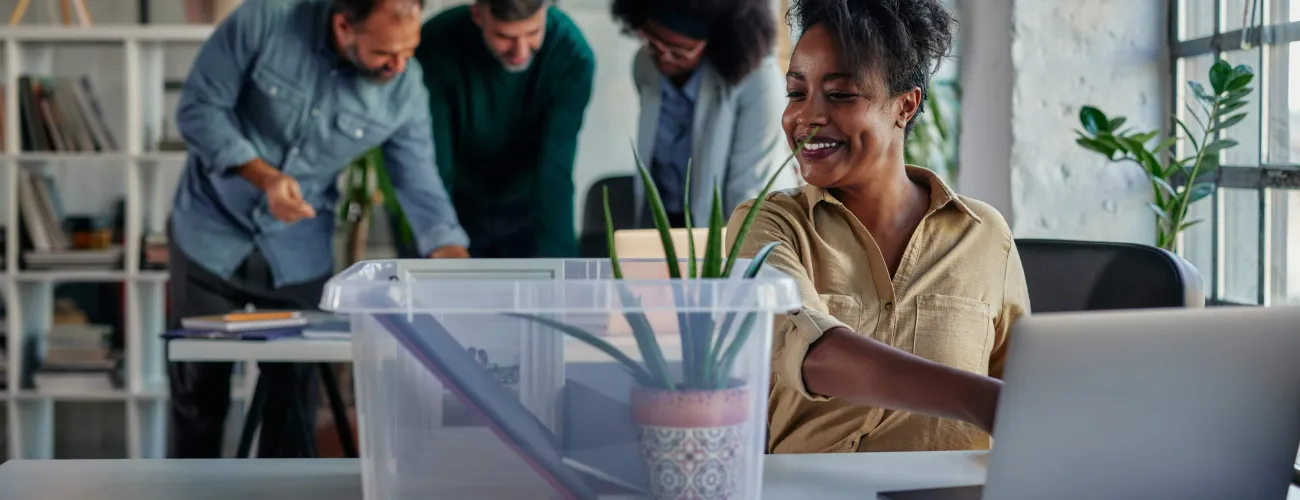 Une femme ramène une boîte d'affaires sur son lieu de travail