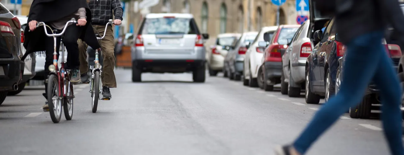 Deux vélos circulent dans une rue avec des voitures