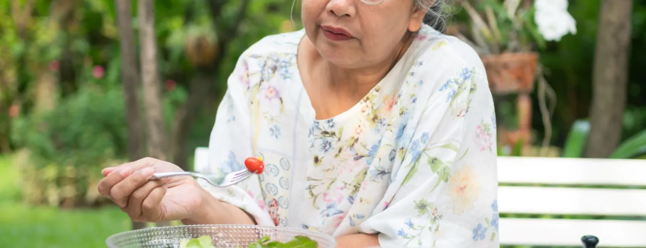 Vielle dame qui mange une salade