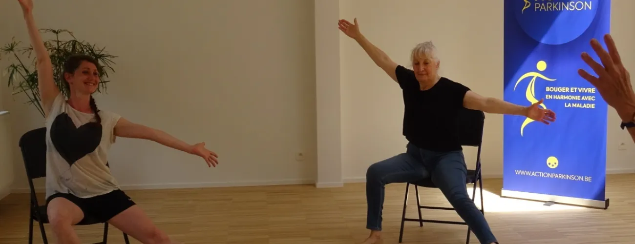 Deux femmes dansent assises sur leur chaise