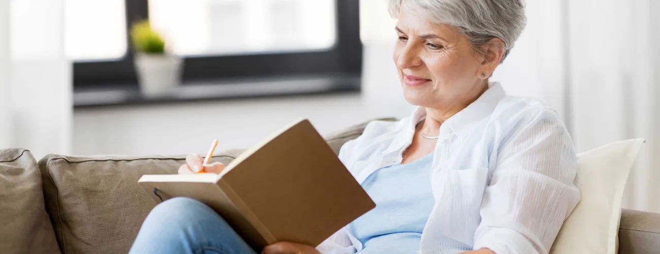 Une dame âgée écrit dans un carnet